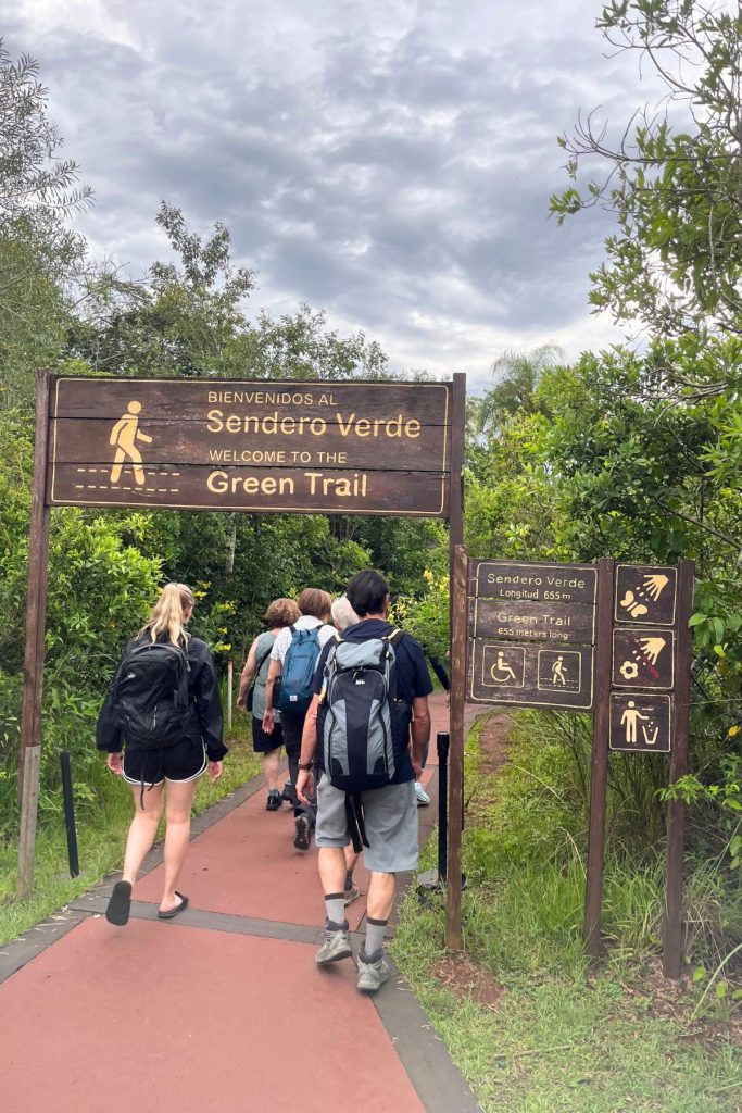 Green Trail sign (Sendero Verde), 655 meters (about 2,150 feet) long, above a red path with hikers