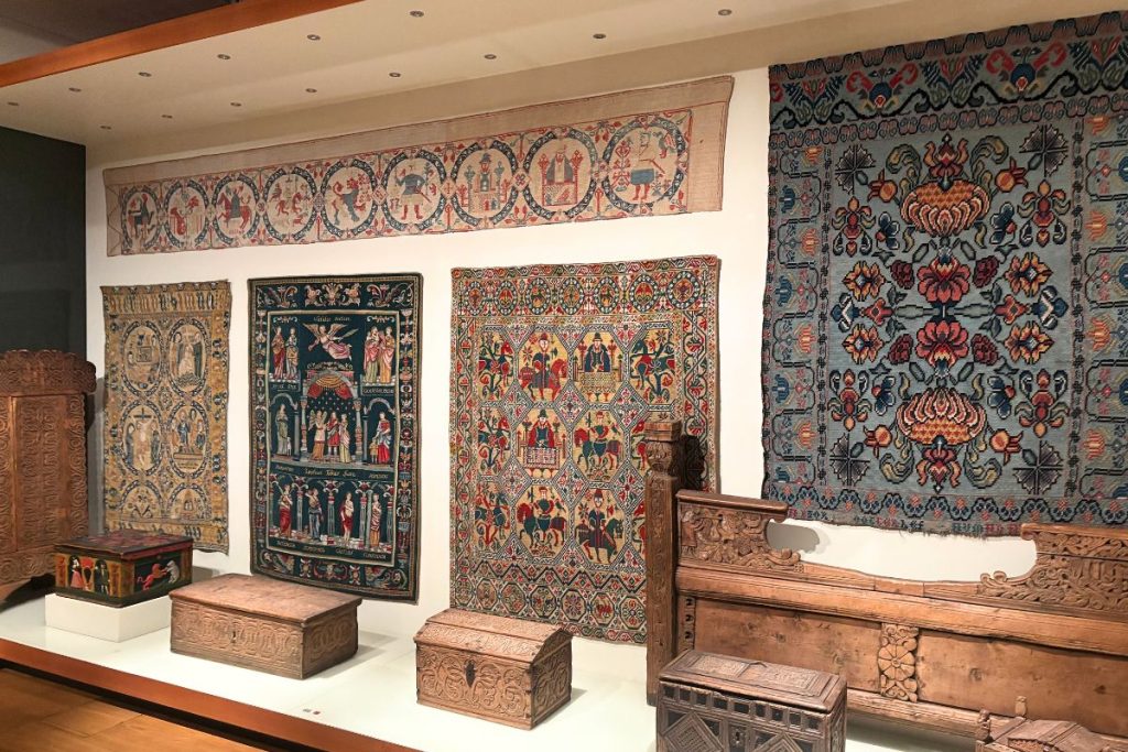 Embroidered wall hangings and carved wooden chests on display at the National Museum of Iceland