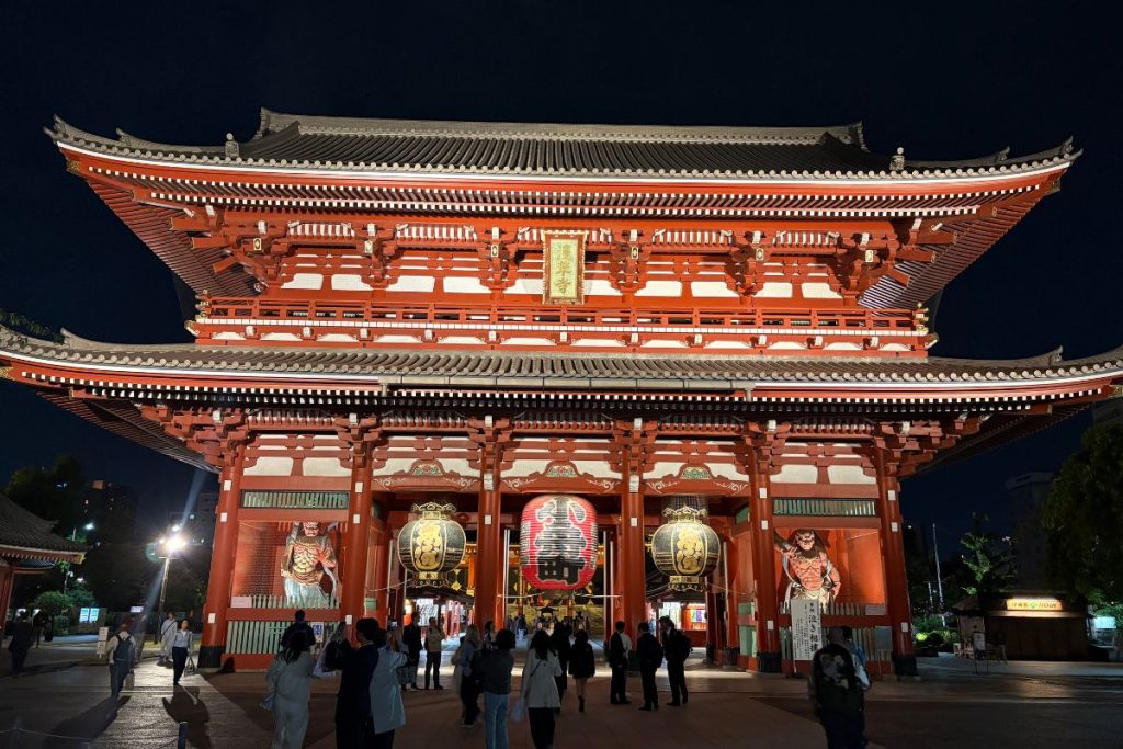 Kaminari-mon Gate at Senso-ji lit up at night with visitors passing through