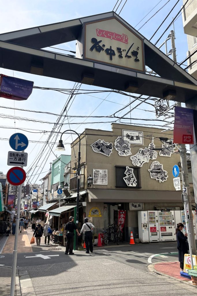 Entrance to Yanaka Ginza shopping street with overhead sign and power lines