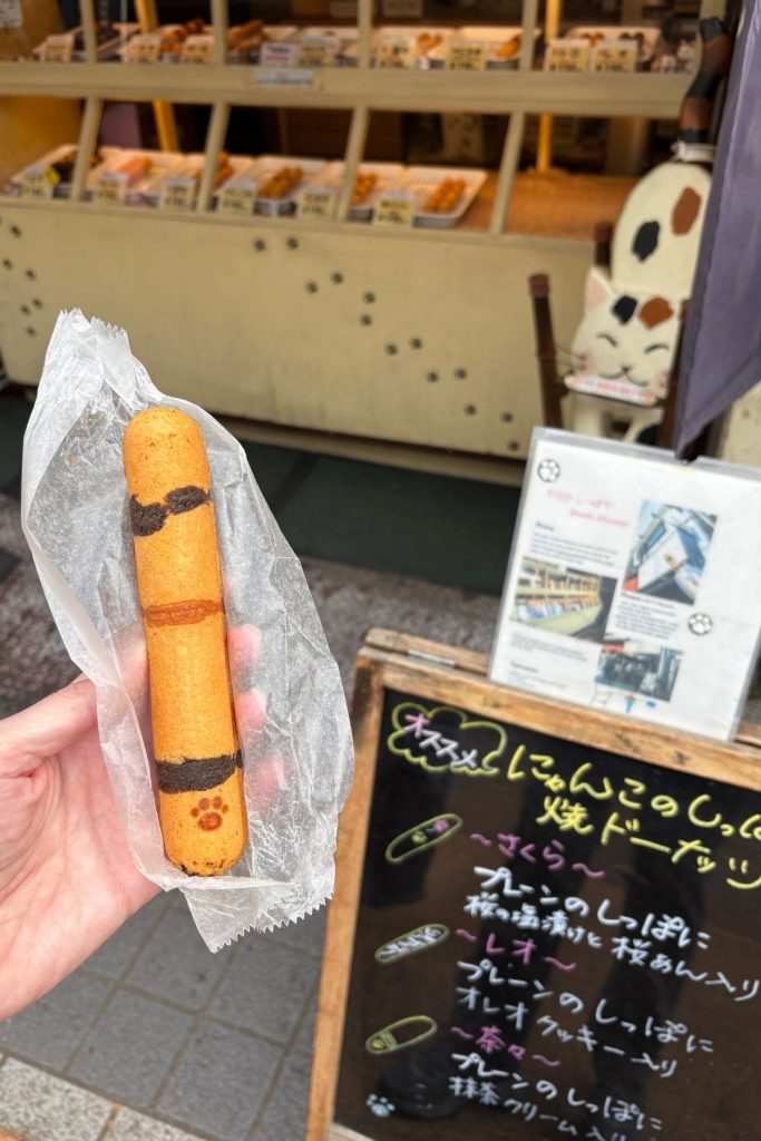 Cat-tail shaped doughnut from Yanaka Shippoya, wrapped in paper with a paw print design