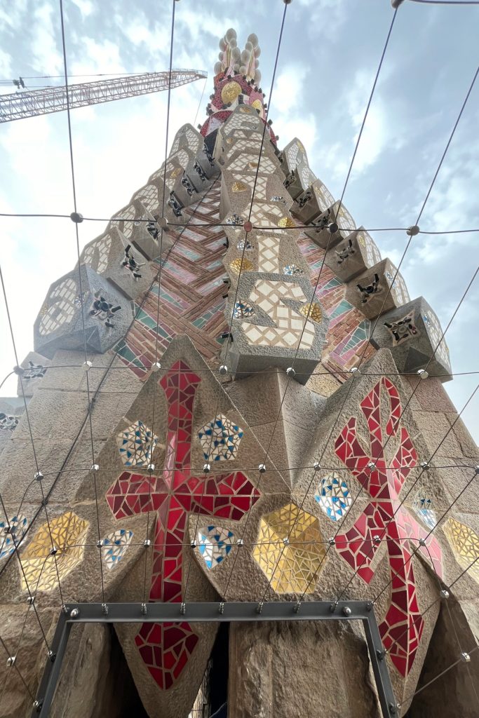 Close-up view of Sagrada Família Passion Tower mosaic spire with red cross detail