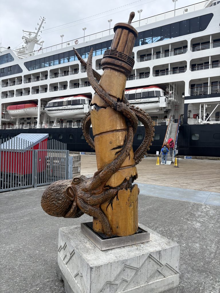 Carved wooden octopus sculpture wrapped around a piling at the Valdez cruise terminal