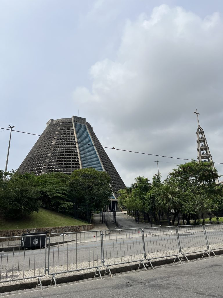 Exterior view of the cone-shaped Metropolitan Cathedral of Rio de Janeiro with its bell tower and cross