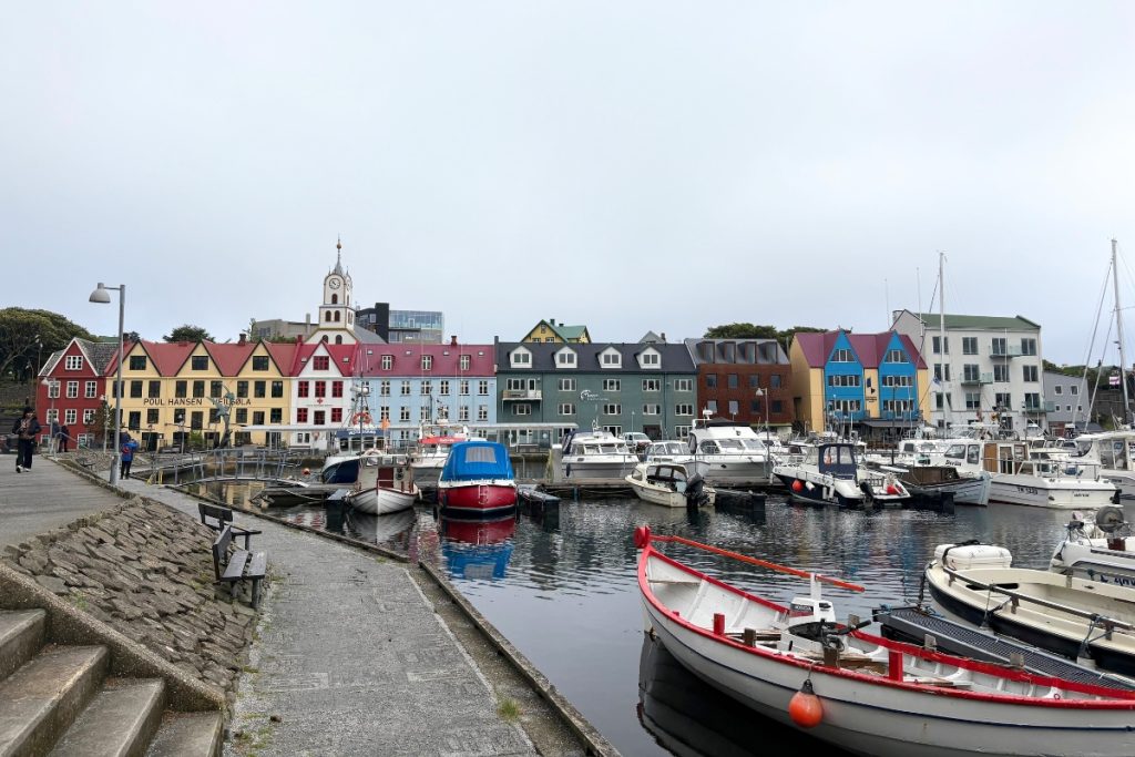 Fishing boats in Tórshavn's harbor with colorful row houses along the waterfront, Faroe Islands