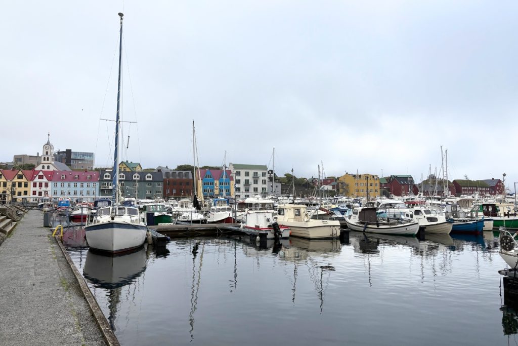 Boats moored in Tórshavn's harbor with colorful buildings along the waterfront, Faroe Islands