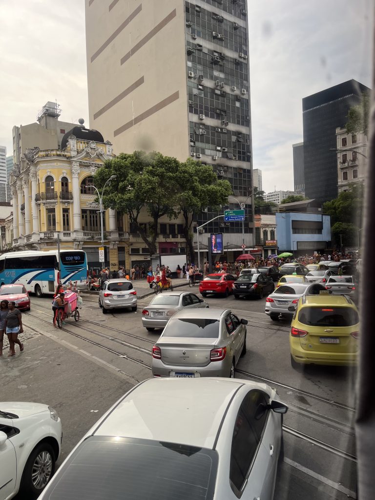Street-side clock reading 08:56 with gridlocked traffic and a colonial-era building in Rio de Janeiro