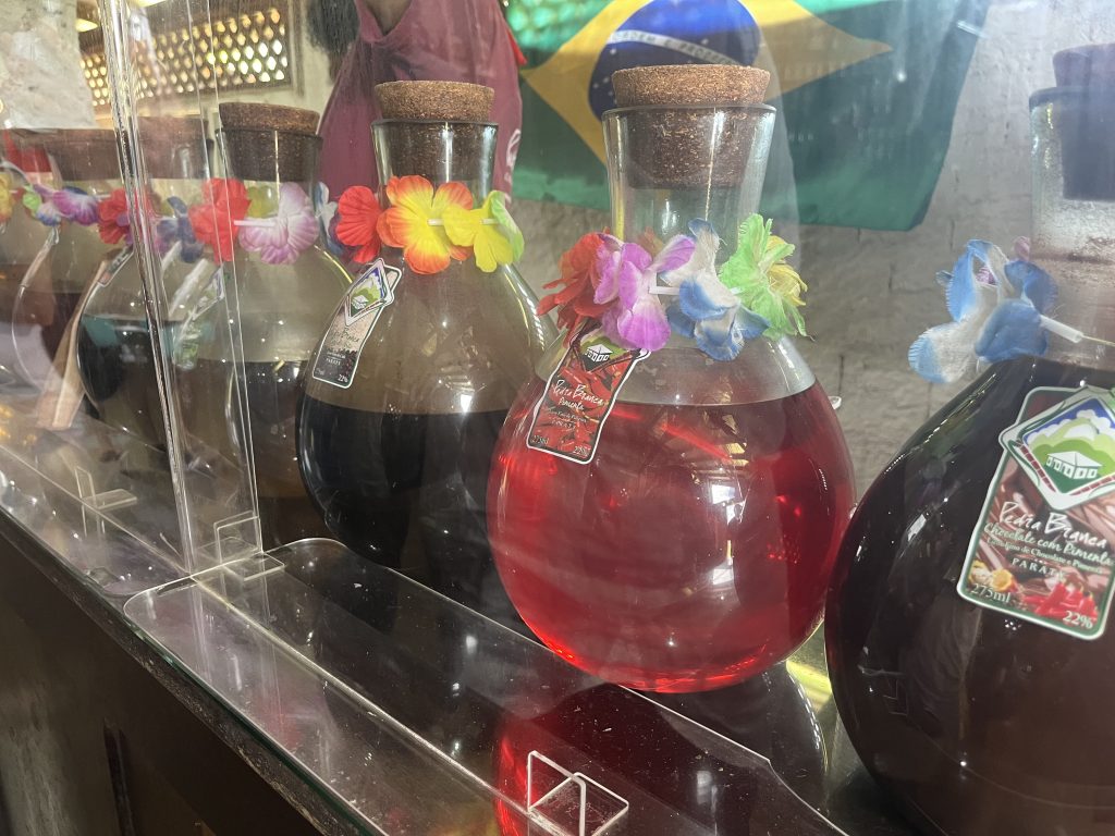Glass bottles of cachaça decorated with colorful Carnaval masks at Pedra Branca distillery