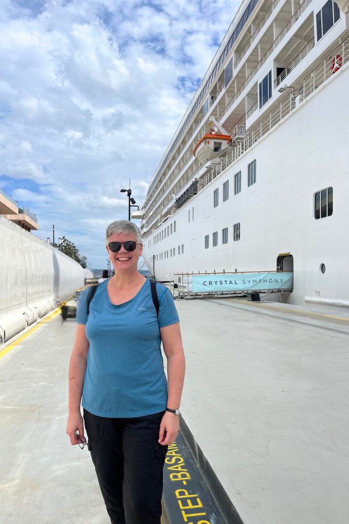 Selfie in front of the docked cruise ship Crystal Symphony, with a banner reading "Crystal Symphony" visible near the gangway entrance.