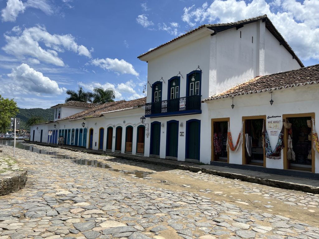 Colonial white buildings with colorful shutters lining a cobblestone street in Paraty, Brazil