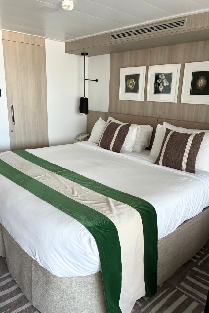 Celebrity Suite bedroom on Celebrity Beyond with king bed and framed artwork