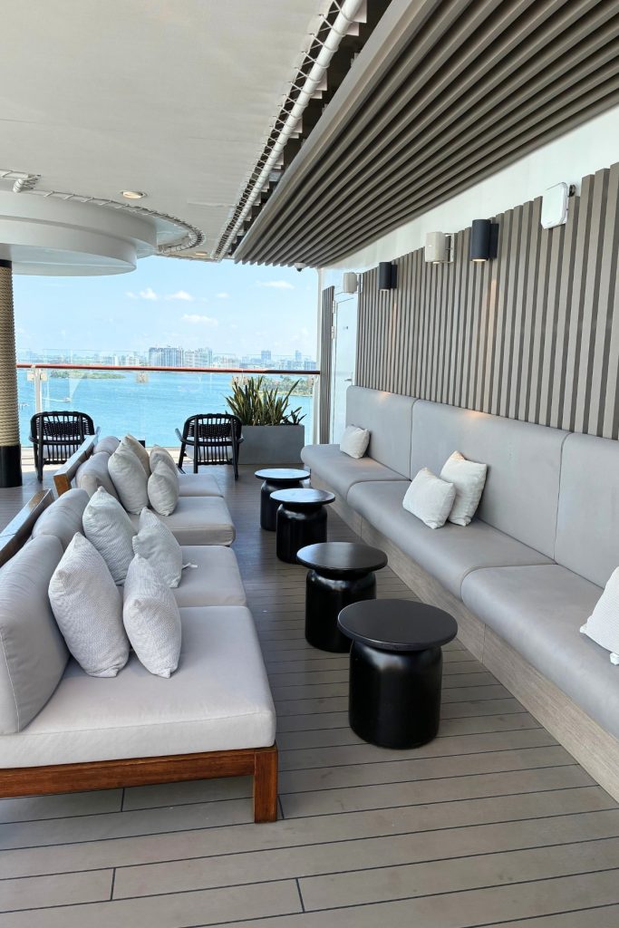 The Retreat lounge deck on Celebrity Beyond with outdoor sofas, side tables, and ocean view