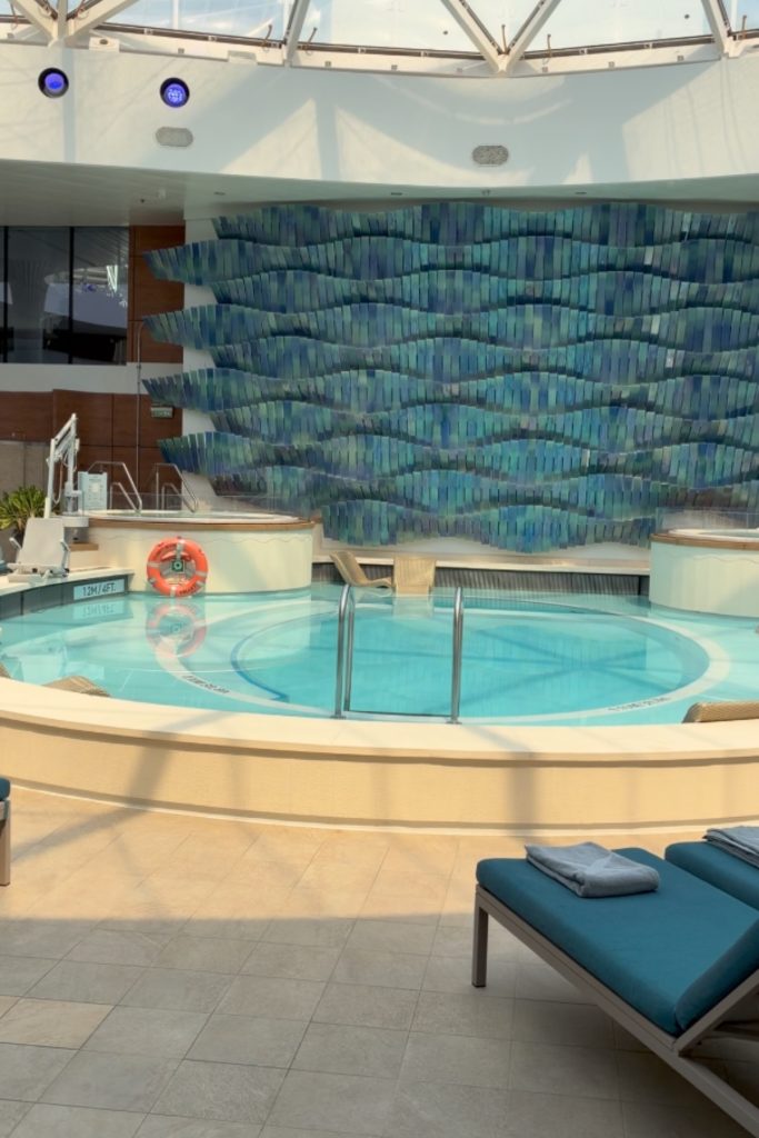 Solarium pool on Celebrity Beyond with mosaic tile wall and covered glass ceiling