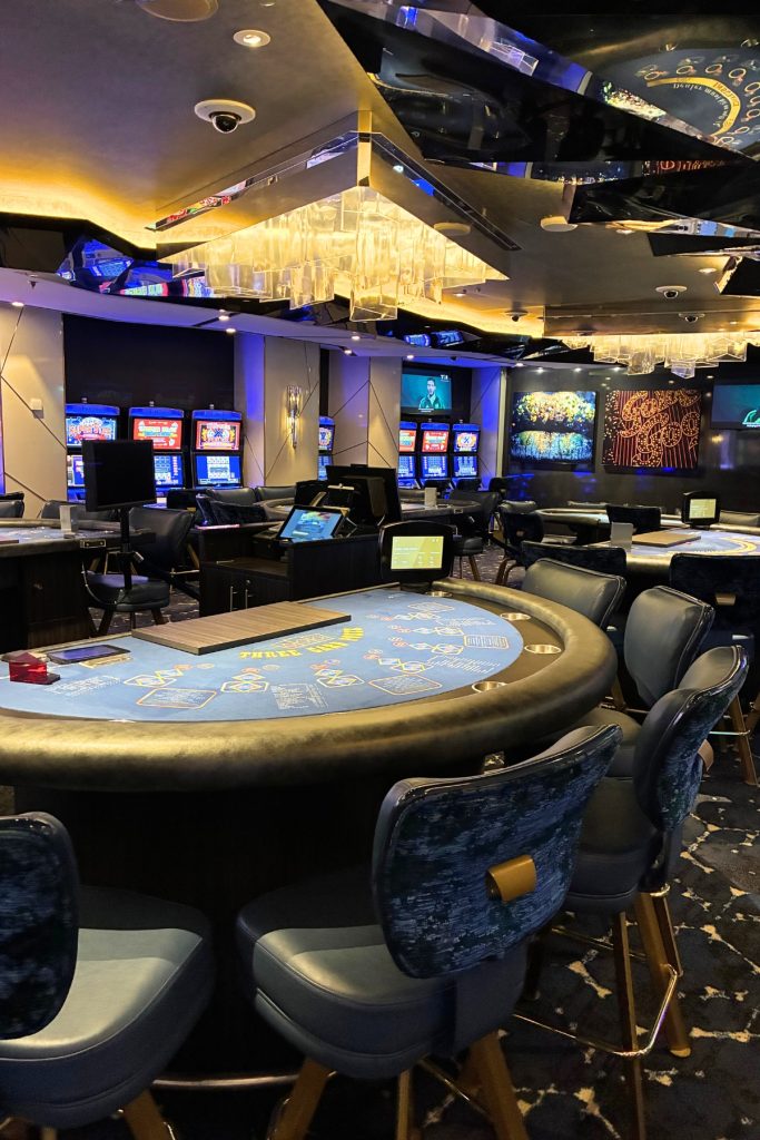 Celebrity Beyond Casino with blackjack table and gaming machines under a chandelier