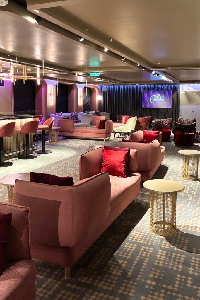 The Club on Celebrity Beyond with pink lounge seating and ambient lighting