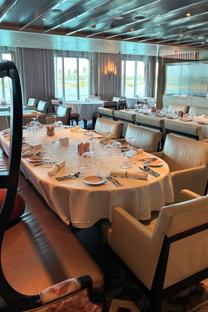 Normandie main dining room on Celebrity Beyond with set tables and water view