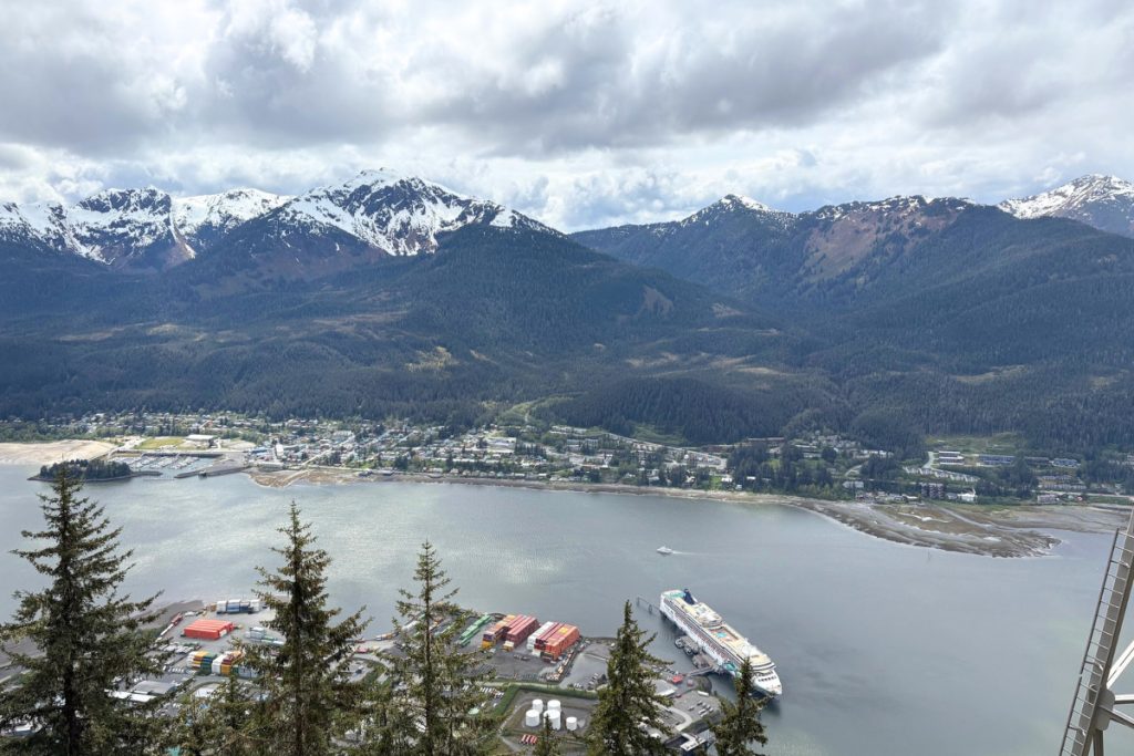 A panoramic view of Juneau, Alaska, and its harbor with docked cruise ships, seen from the Mount Roberts tram summit.