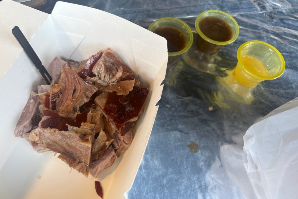 Takeout box of shredded lechon pork with crackling skin, served with three dipping sauces, in La Loma, Manila