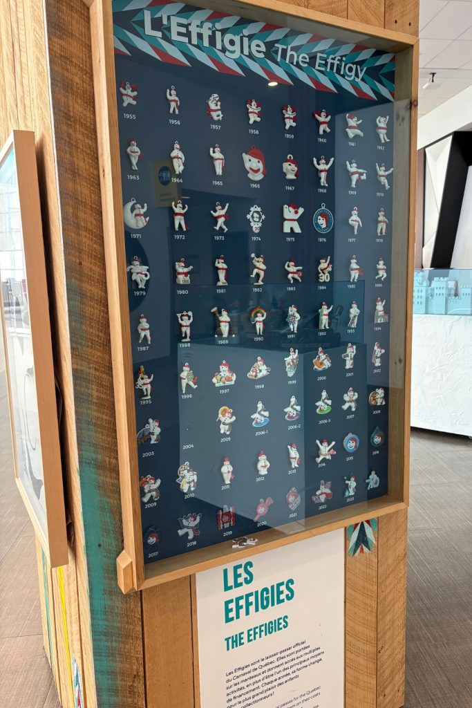 A display case of Bonhomme Carnaval effigy pins, organized by year from 1955 to the present.
